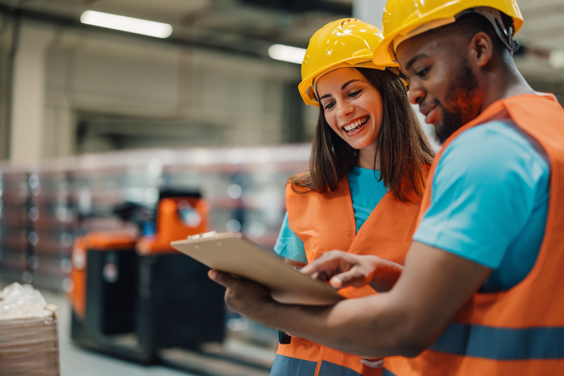 Warehouse workers having fun while checking inventory using a clipboard